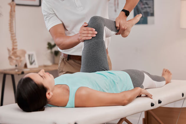 Elite Player Performance physiotherapy consultation with a therapist assisting a patient in a clinical setting.